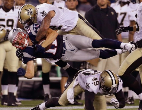 New England Patriots wide receiver Julian Edelman (11) is hit by New Orleans Saints linebacker Jonathan Casillas (52) as they sail over Saints defensive back Marquis Johnson (49) during their first NFL preseason football game in Foxborough, Mass., Thursday, Aug. 9, 2012. (AP Photo/Elise Amendola)