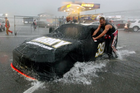 Crew members push Ryan Newman's car in a downpour that shortened the NASCAR Sprint Cup Series auto race, Sunday, Aug. 5, 2012, at Pocono Raceway in Long Pond, Pa. Jeff Gordon won. (AP Photo/Mel Evans)