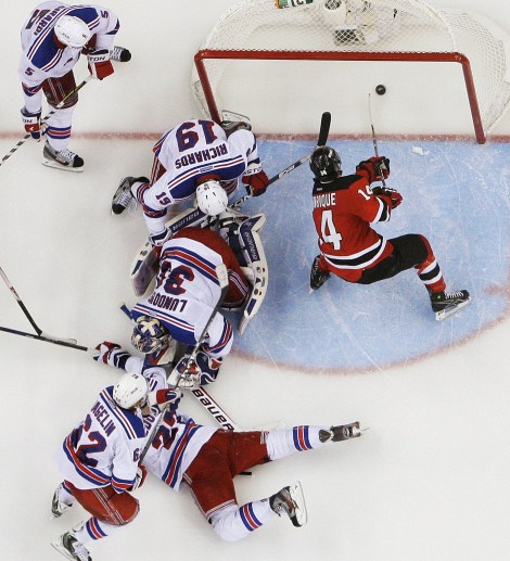 New Jersey Devils' Adam Henrique (14) scores during the overtime of Game 6 of the NHL hockey Stanley Cup Eastern Conference finals, as New York Rangers' Henrik Lundqvist (30), Brad Richards (19), and Carl Hagelin (62) defend, Friday, May 25, 2012, in Newark, N.J. The Devils won 3-2. (AP Photo/Frank Franklin II)