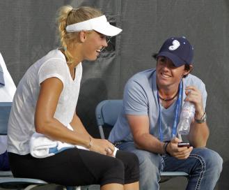 Rory McIlroy chiacchiera con Caroline Wozniacki durante una pausa degli allenamenti di tennis della danese (Foto AP/Al Behrman)