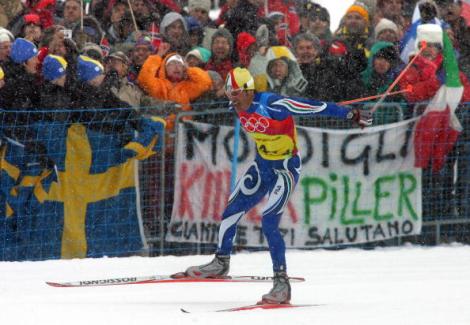 Pietro Piller Cottrer trascina la staffetta azzurra all'oro nella 4x10 km sulla neve di Pragelato, tra le imprese dei Giochi Olimpici Invernali di Torino 2006.   AFP PHOTO / DDP/JOHANNES SIMON  (Photo Johannes Simon/AFP/Getty Images)