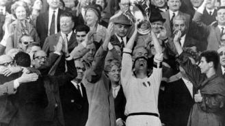 Il capitano Cesare Maldini alza al cielo la Coppa. A destra un giovanissimo Gianni Rivera (Foto Gazzetta)